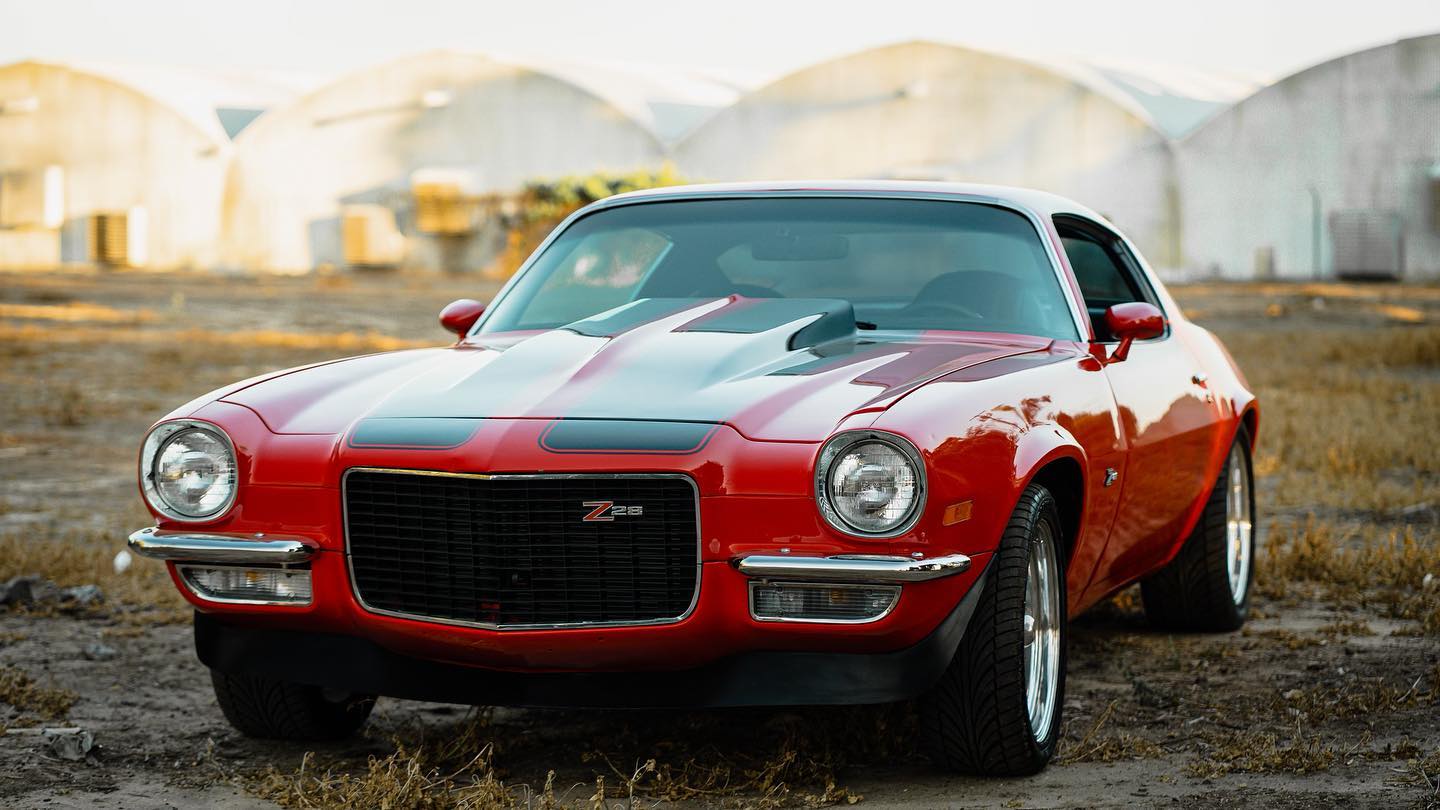 Red Chevrolet Camaro Z28 photographed outdoors with tinted glass